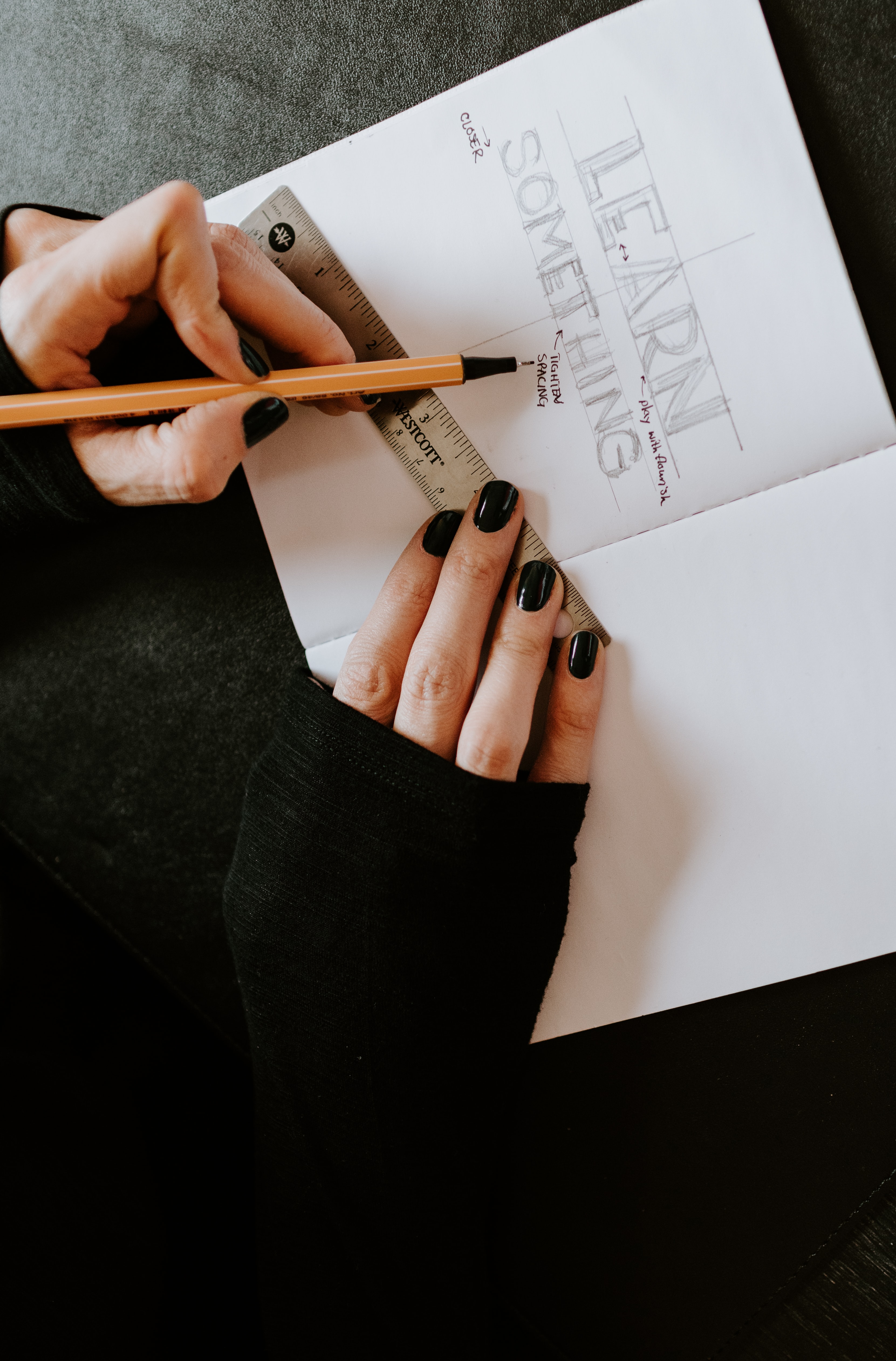 Lady's hand using a ruler for a project